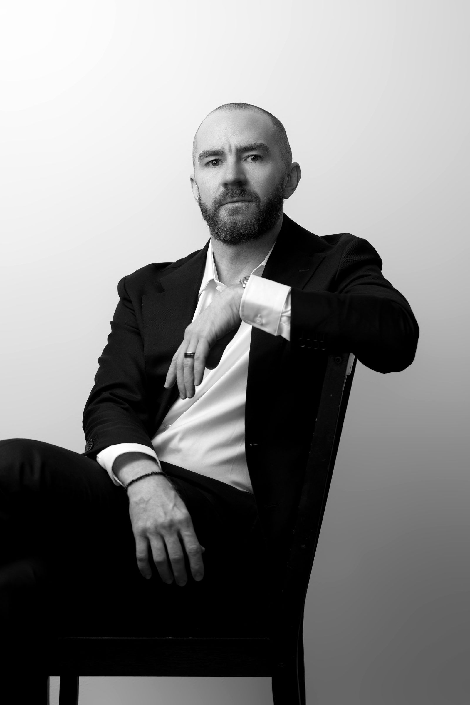 Guy Muller seated on a white backdrop, looking direct