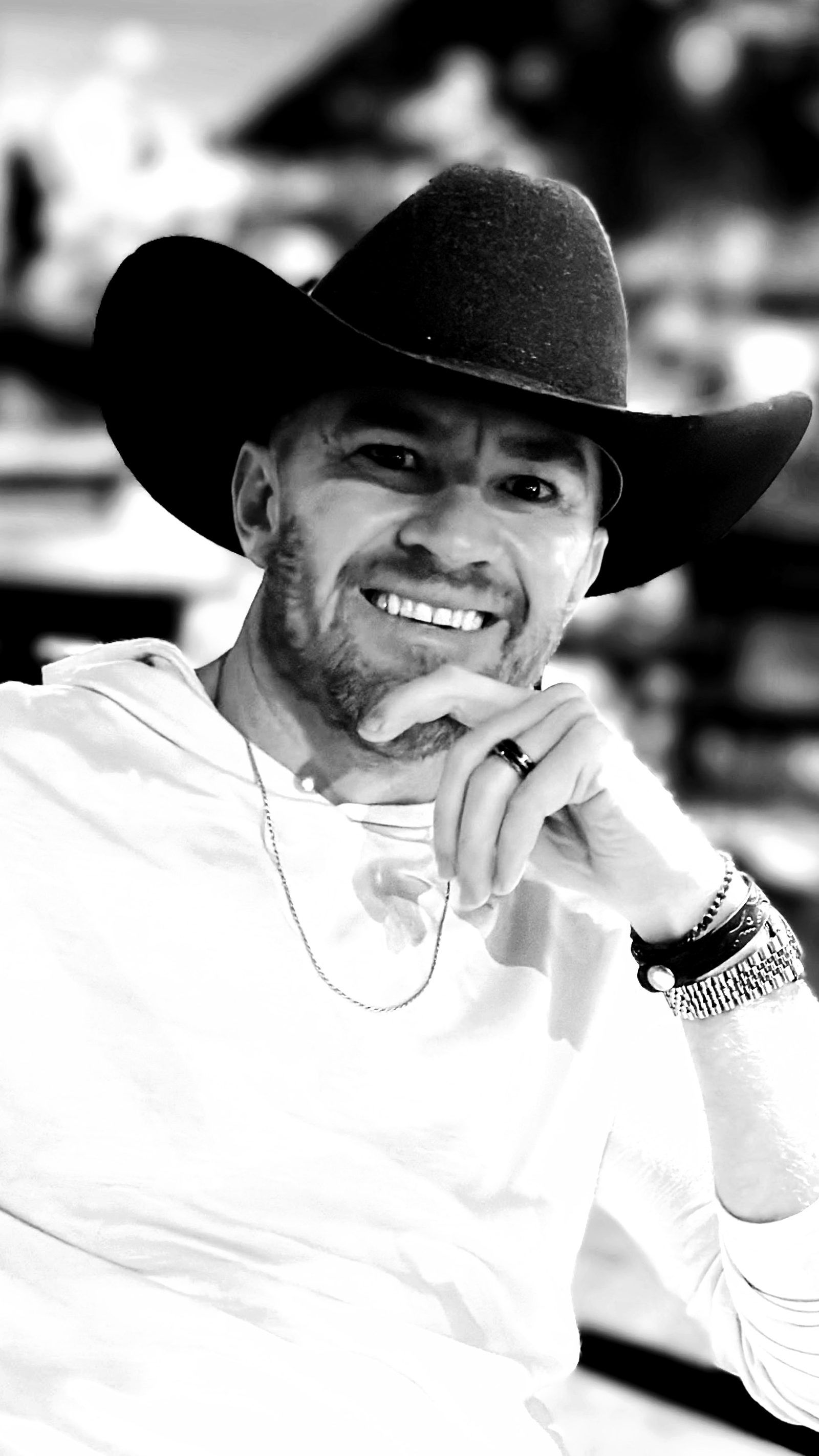 Guy Muller in a black cowboy hat, chin resting on his hand